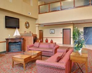 a living room with pink furniture and a fireplace at Quality Suites Near Cedar Creek Lake in Mabank