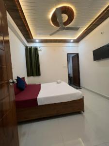 a bedroom with a bed and a ceiling at Goroomgo YP Stays Dehradun - Parking facilities - Best Seller in Dehradun