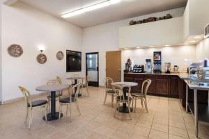 a restaurant with tables and chairs and a kitchen at Rodeway Inn in Gallup