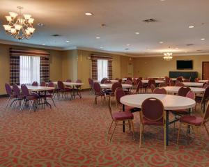 a conference room with tables and chairs and a podium at Quality Suites Near Cedar Creek Lake in Mabank
