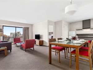 a living room with a table and chairs and a couch at Mantra on Hay Perth in Perth