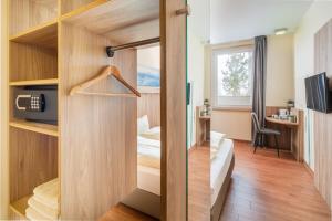 una habitación de hotel con puerta entreabierta a un dormitorio en Hotel Neumarkt, en Berg bei Neumarkt