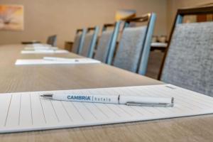 a pen sitting on top of a notebook on a table at Cambria Hotel Spokane Airport in Spokane