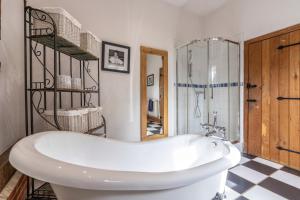 eine weiße Badewanne im Bad mit Dusche in der Unterkunft Doves Barn in Needham Market