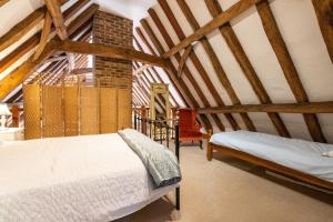 two beds in a room with wooden beams at Doves Barn in Needham Market