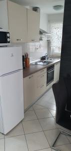 eine Küche mit weißen Schränken und einem weißen Kühlschrank in der Unterkunft Apartment Murati in Vicani