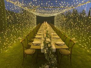 uma mesa longa com cadeiras, luzes e luzes em Villa Rignana - Chianti Weddings em Greve in Chianti