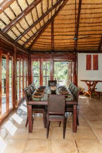 a dining room with a wooden table and chairs at Duma Manzi Eco Lodge & Spa in Richmond