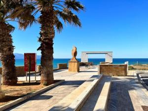 a walkway near the beach with palm trees at Scorcio di Mare By Dimora Hub in Balestrate