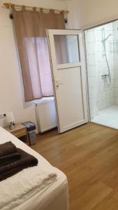 a room with a bed and a shower and a door at Pension Seevetal in Seevetal