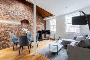 ein Wohnzimmer mit Sofa und Ziegelwand in der Unterkunft Bright Marylebone Apartment in London