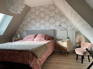 Le Doux Refuge في Esquay-sur-Seulles: غرفة نوم بسرير وكرسي في العلية