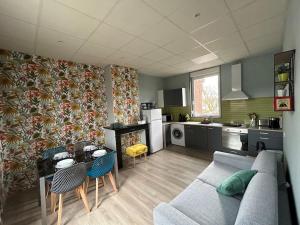 a living room with a couch and a kitchen at Martine: appartement 1er étage in Cambrai