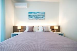 um quarto com uma cama grande e 2 candeeiros em Milena Suite Apartments em Alghero