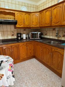 a kitchen with wooden cabinets and a microwave at Casa Pepa in Puerto de Mogán