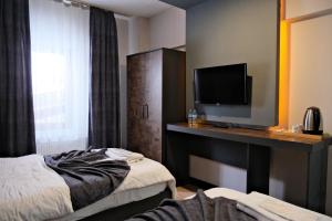 a hotel room with two beds and a flat screen tv at Atlas Otel in Erzurum