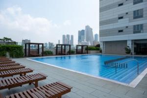 a swimming pool on top of a building with benches at Luxe CL in Colombo