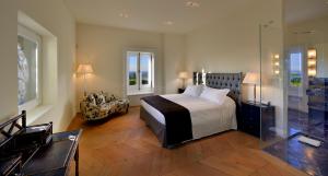 a bedroom with a king sized bed and a chair at Villa Amagioia by Palazzo di Varignana in Varignana