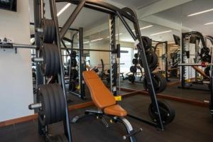 a gym with several tread machines and a chair at Luxe CL in Colombo