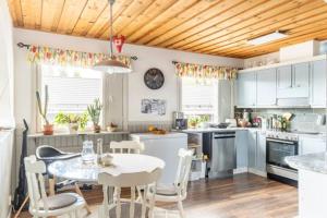 a kitchen with white cabinets and a table and chairs at Beautiful Expansive House with Sea views, large private bedrooms available in shared house in Vaasa