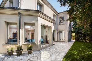an exterior view of a house with large windows at Villa Stella - 10 chambres - 5 salles de bains - Château de Versailles à pied in Le Chesnay
