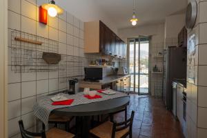 a kitchen with a table and some chairs and a refrigerator at L’Attico di Susanna in Verbania