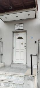 a white door on a building with a sign on it at Skordas Comfy Rent Rooms in Thessaloniki