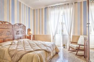 - une chambre avec un grand lit et une fenêtre dans l'établissement Casa delle Rose - Together in Tuscany, à Cortone