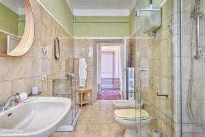 La salle de bains est pourvue d'un lavabo, de toilettes et d'une douche. dans l'établissement Casa delle Rose - Together in Tuscany, à Cortone