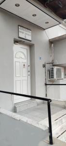 a white building with a white door and a staircase at Skordas Comfy Rent Rooms in Thessaloniki