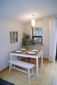 mesa blanca y banco en la sala de estar en Bright spacious mews in great location, en Booterstown
