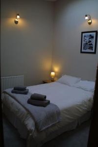 1 dormitorio con 1 cama blanca y 2 toallas en Bright spacious mews in great location, en Booterstown