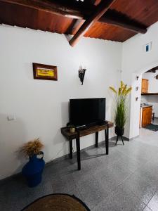 ein Wohnzimmer mit einem TV auf dem Tisch in der Unterkunft É um Descanso in Campinho