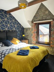 una camera da letto con un letto con due asciugamani blu sopra di Cadwgan House a Rhayader