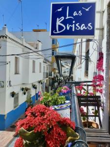 a balcony with flowers and a sign on a building at Las Brisas Estepona in Estepona