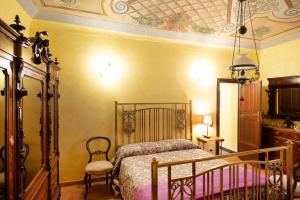 a bedroom with a bed and a chair and a ceiling at Degli Alessandri Palace in Sassoferrato