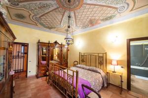 a bedroom with a bed and a painting on the ceiling at Degli Alessandri Palace in Sassoferrato