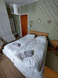 een slaapkamer met een groot bed met witte lakens bij Private Room in Pink House in Pajala