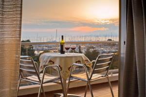 una mesa con 2 copas de vino en el balcón en Marina Alimos Hotel Apartments, en Atenas