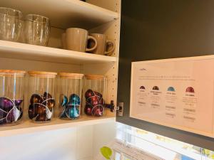 a shelf filled with glass jars with bowls and mugs at 'Your Place on Davidson' in Mount Isa