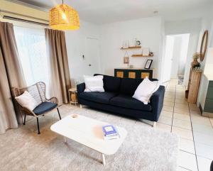 a living room with a black couch and a coffee table at 'Your Place on Davidson' in Mount Isa