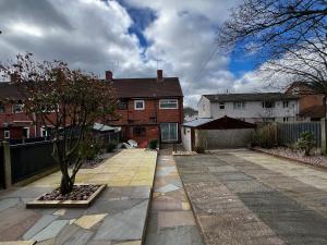 a house with a tree in the middle of a driveway at Springfield House- Near Newcastle Centre, Hospital and Keele University! in Stoke on Trent