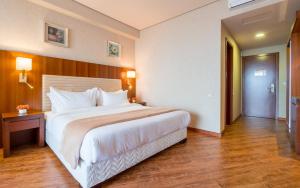 Dreamland Oasis Hotel في شاكفي: سرير أبيض كبير في غرفة الفندق