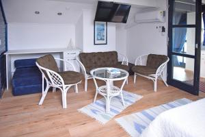 a living room with a couch and a table and chairs at Salvus Apartma - Sun & Moon in Lendava