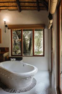 a white bath tub in a room with a window at Duma Manzi Eco Lodge & Spa in Richmond