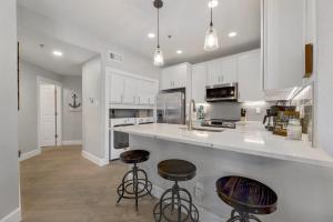a kitchen with white cabinets and two bar stools at ILT 3221 Lakeside Serenity in Lago Vista