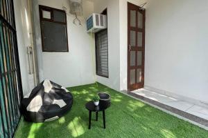 Habitación con suelo verde, puerta y mesa. en Compact & Cozy 2BHK@GolfCourseRoad, en Gurgaon