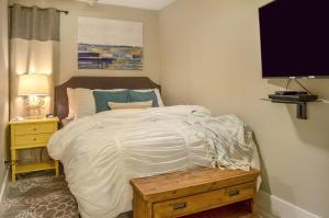 1 dormitorio con cama blanca y mesa de madera en CDM 351 - Serendipity Sunrise, en Galveston