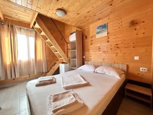 a bedroom with a bed in a wooden cabin at Cazare Nicoleta in Vadu