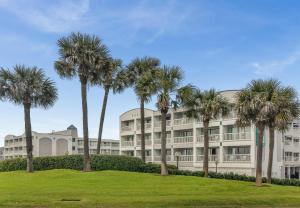 une rangée de palmiers devant un bâtiment dans l'établissement CDM 201 - Pier Paradise, à Galveston